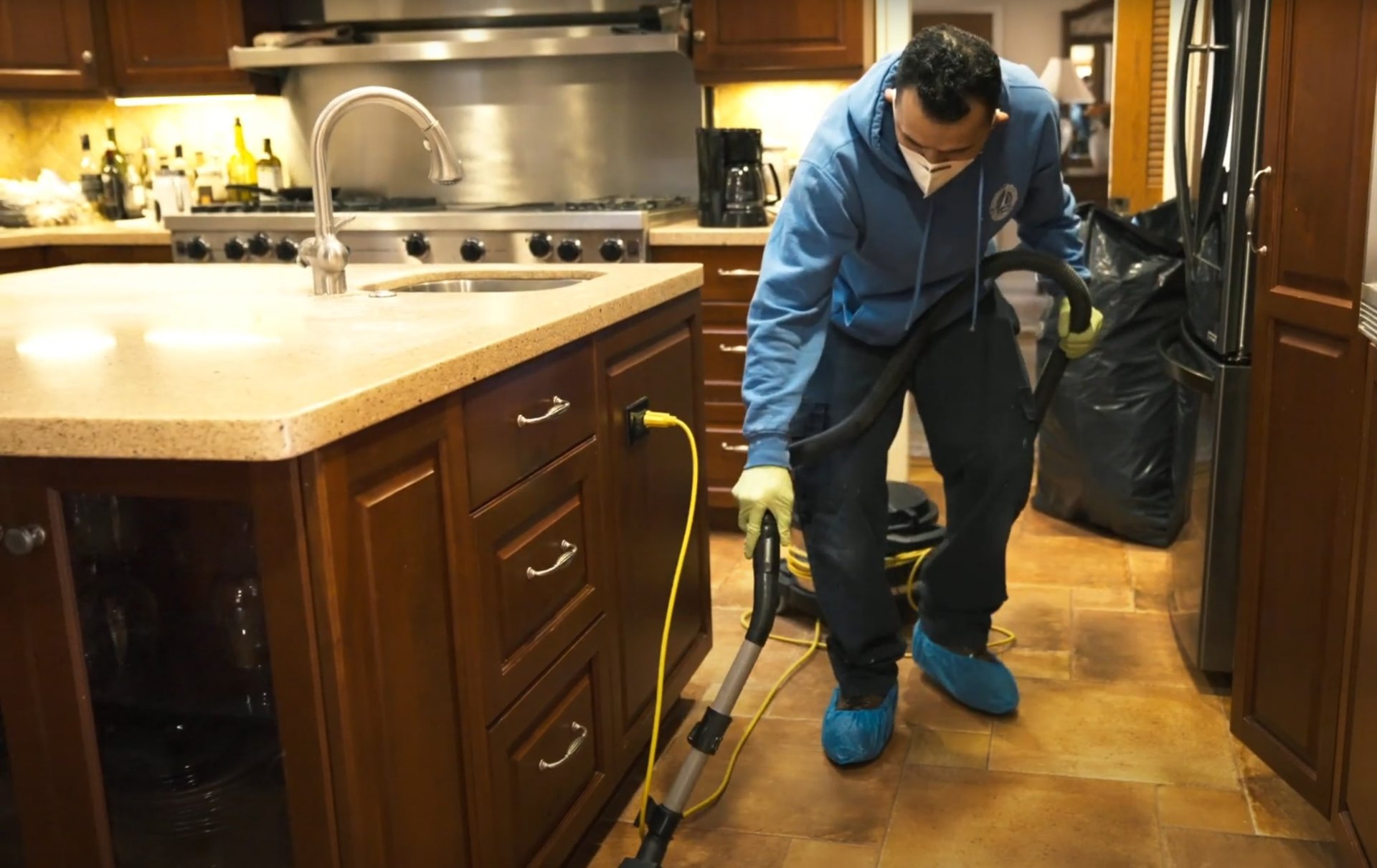 Professional water damage restoration technician using advanced drying equipment Professional technician using specialized equipment for floor drying and water damage restoration