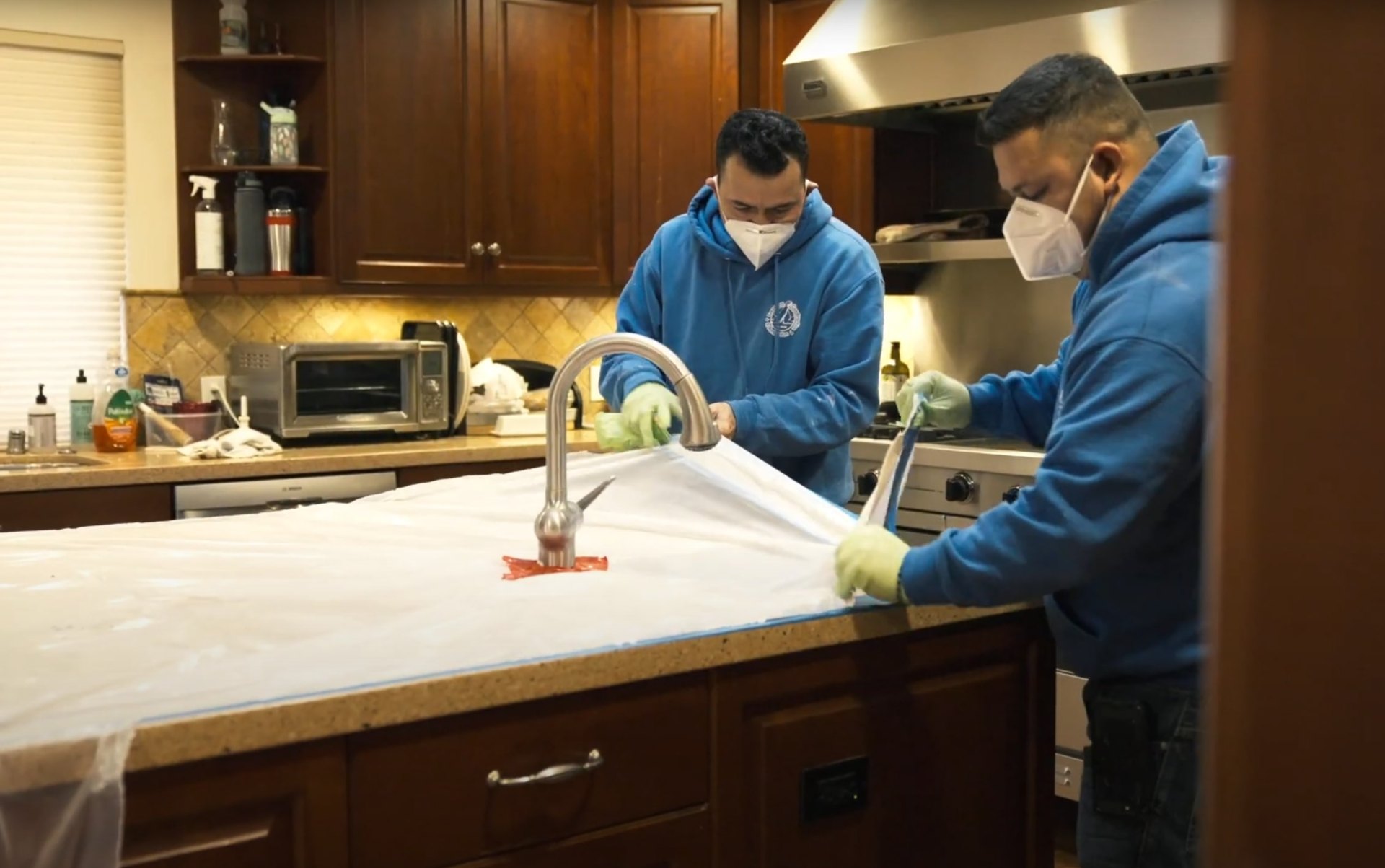 Professional water damage cleanup and sanitization services in Johns Creek Water damage restoration professionals cleaning and sanitizing kitchen surfaces