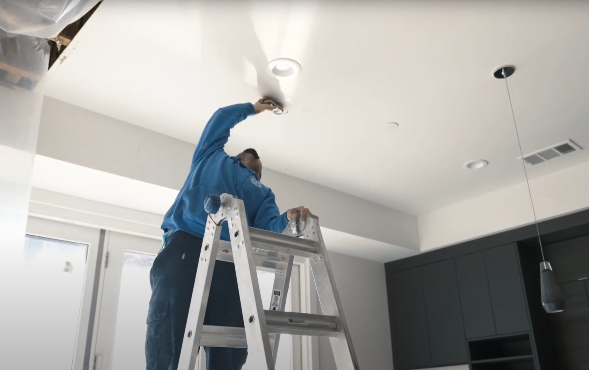 Professional ceiling repair and water damage restoration services Water damage restoration technician working on ceiling repair and restoration